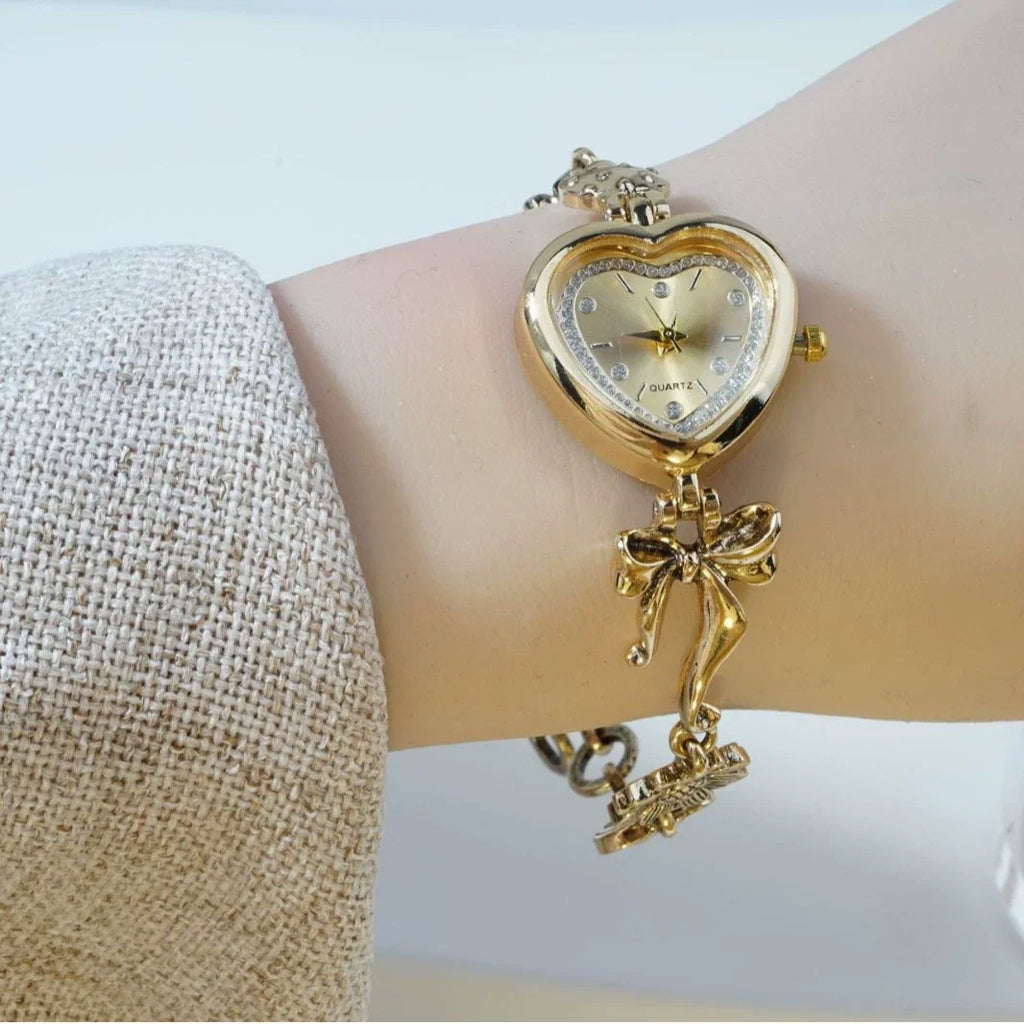 Heart Case Bracelet Watch — Gold-Tone, Crystal Bezel, Champagne Dial & Bow Charm Chain, Women