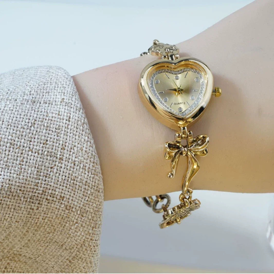 Heart Case Bracelet Watch — Gold-Tone, Crystal Bezel, Champagne Dial & Bow Charm Chain, Women